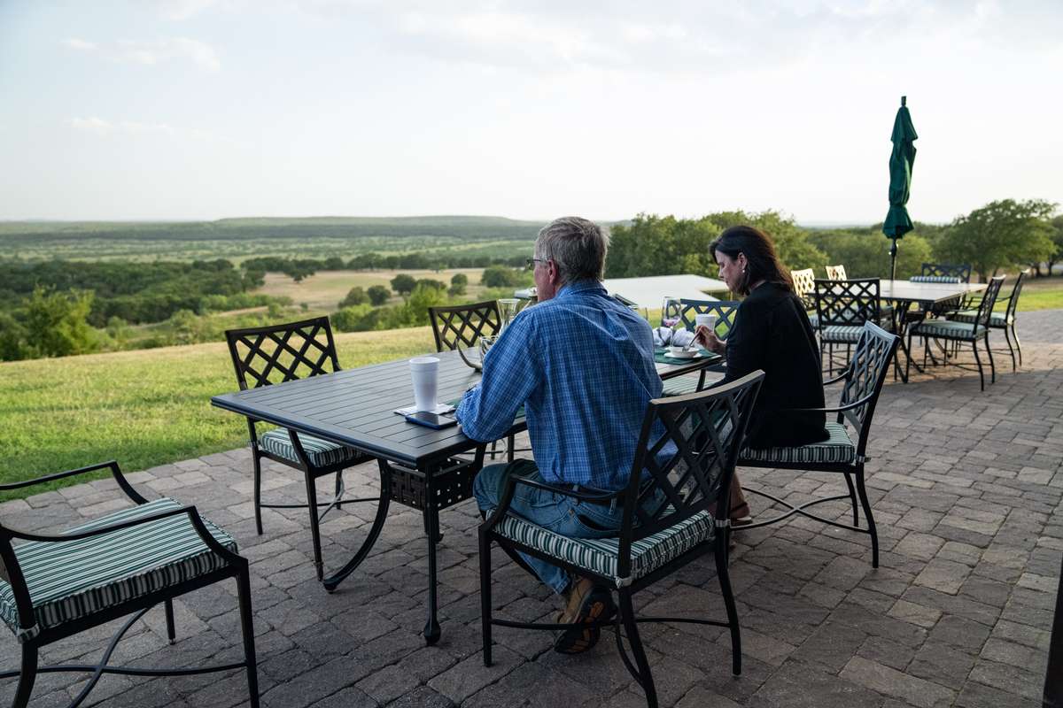 Corporate Events A man and woman sitting on the patio enjoying breakfast with a view at Greystone Castle Lodge - A Luxury Corporate Events Ranch in North Texas